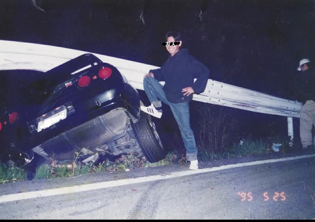 Fotografia d'archivio: una persona appoggiata a una Nissan Skyline nera, con data impressa 1995.